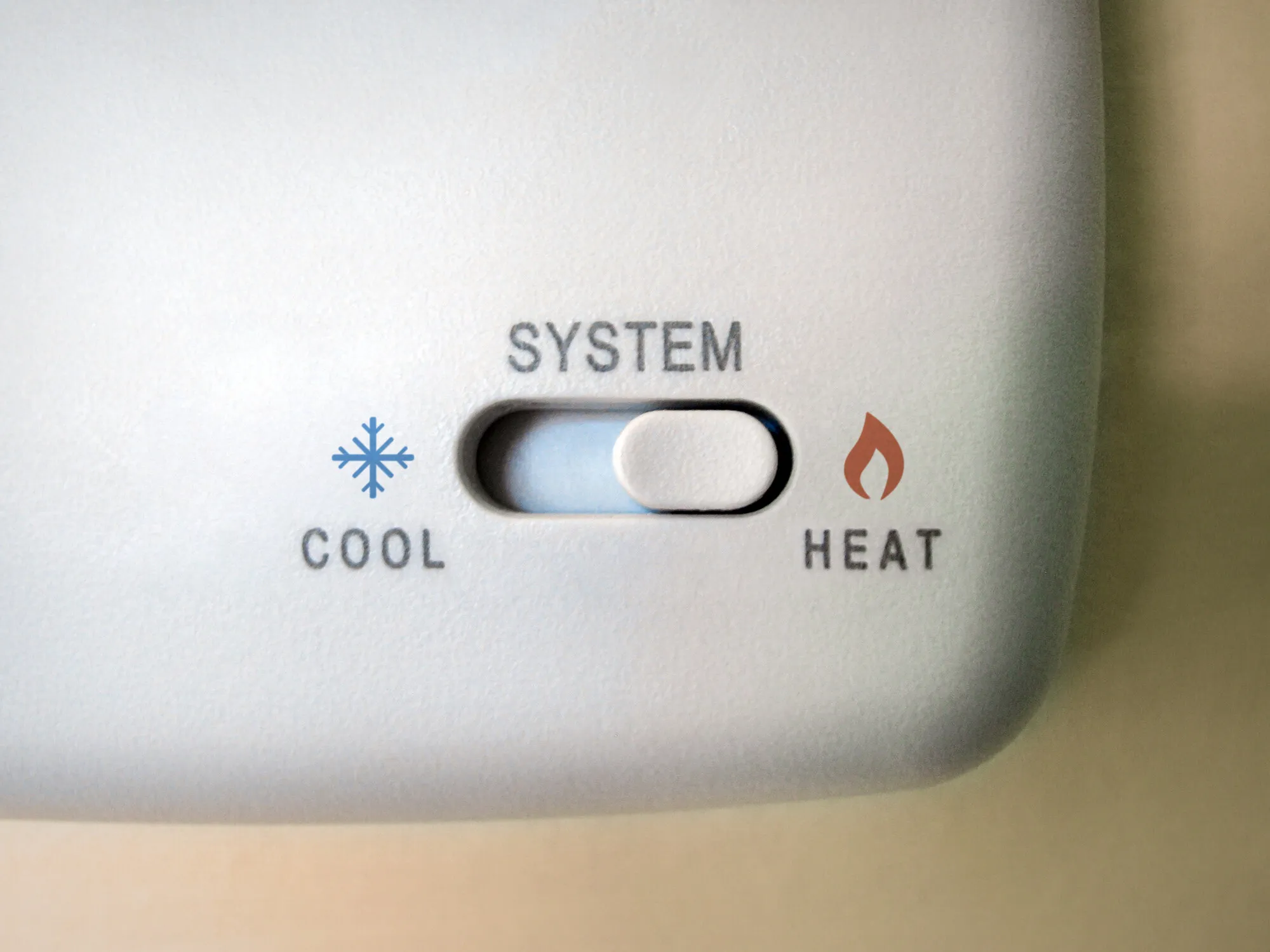 Homeowner adjusting a digital thermostat on the wall